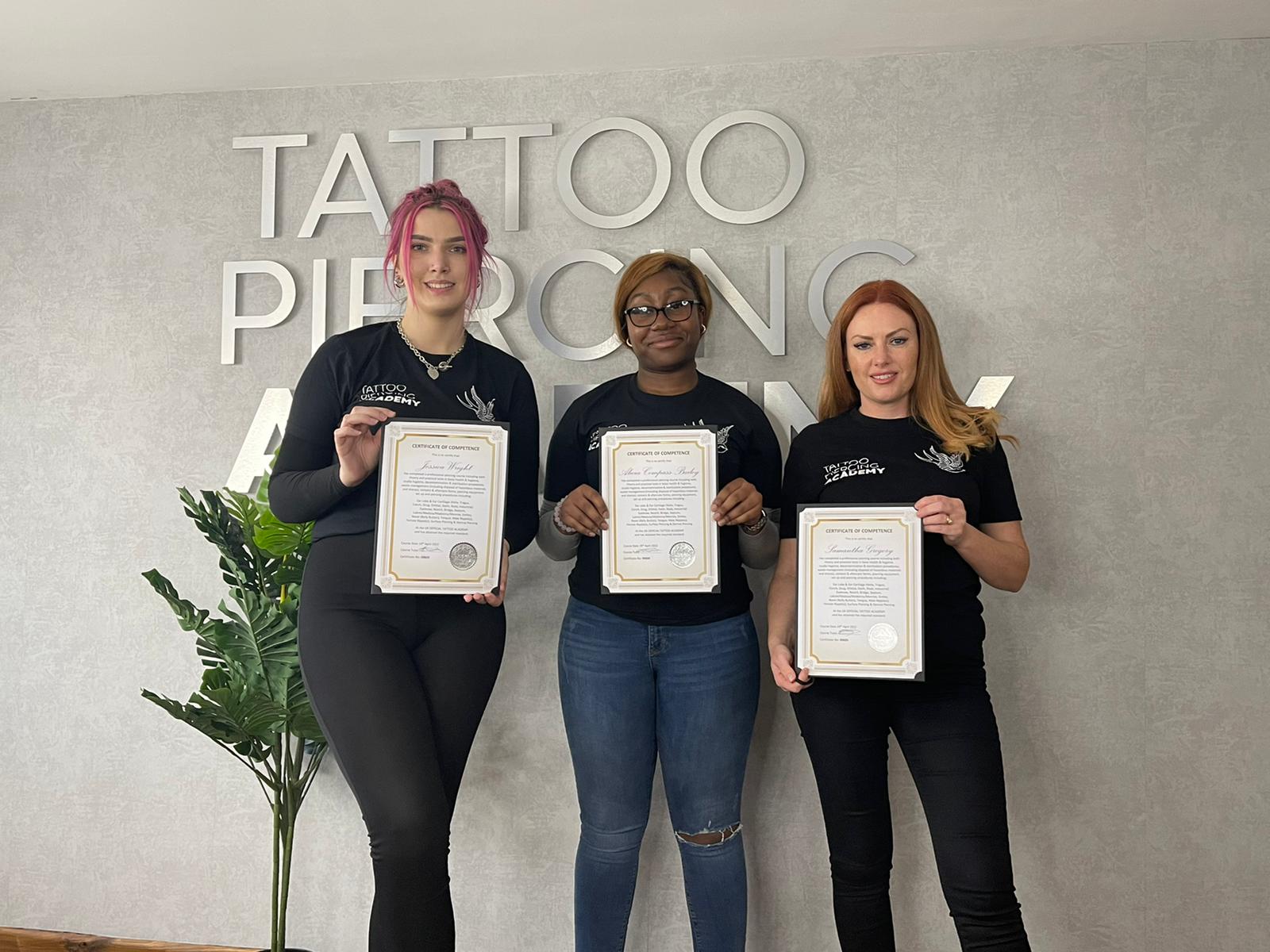 Piercing course students holding their CPD certificates of competence